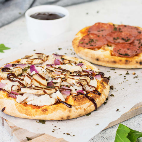 Hand spreading tomato polpa onto Plain Artisan Pizza Base