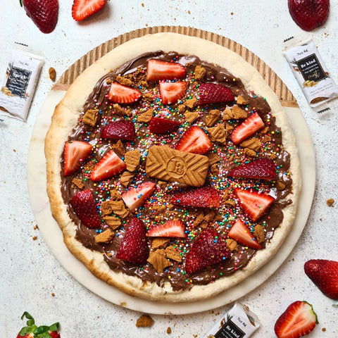 Plain base dessert pizza with straweberries, nutella and caramelised speculoos biscuit